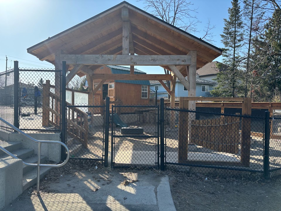 Fenced entrance gate leading to the covered outdoor play pavilion