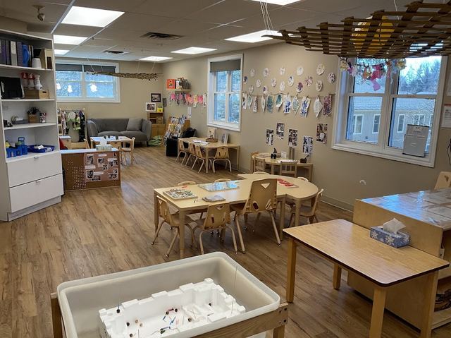 Sensory bin table among wooden shelving units stocked with hands-on materials
