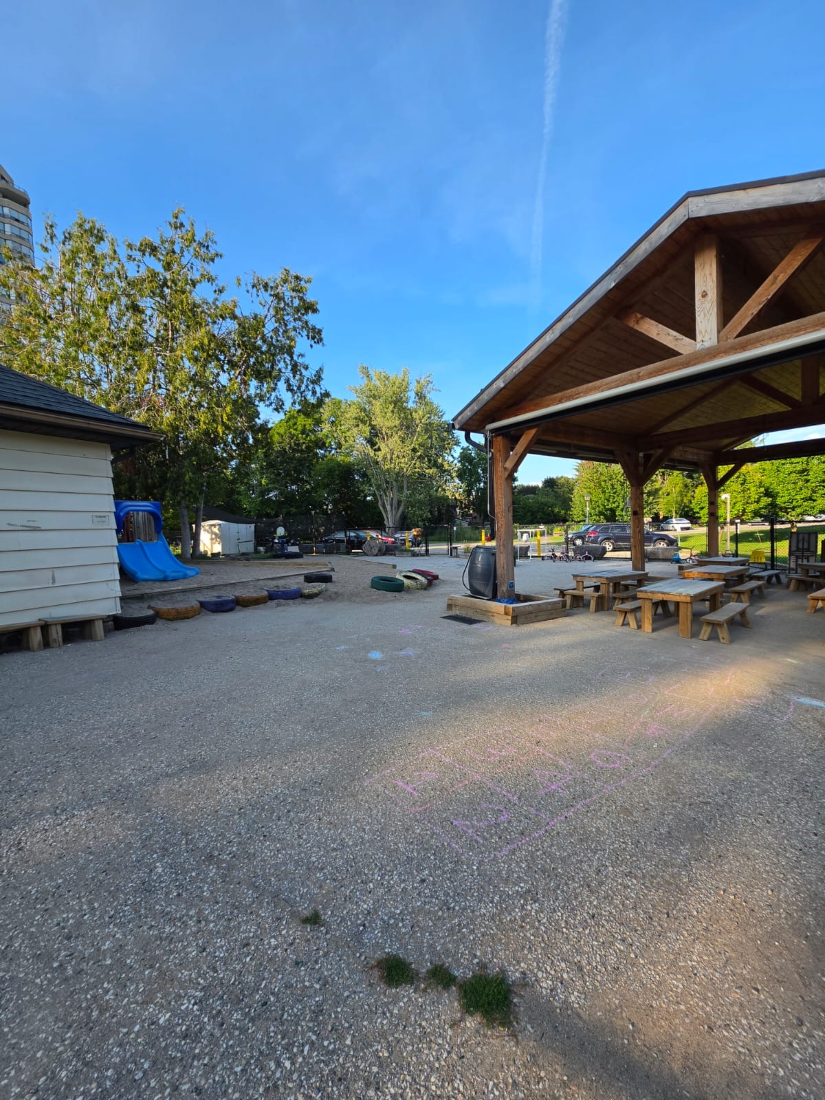 Sandbox area with a slide and a row of tricycles under the pavilion